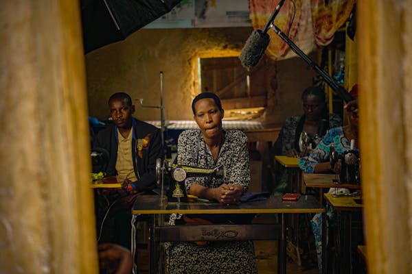 Group of tailors in workshop with sewing machines